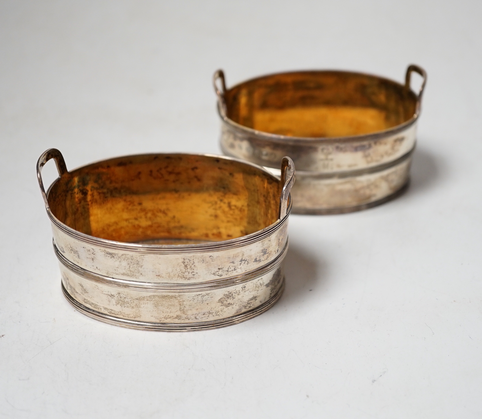 A pair of George III silver salts, modelled and oval two handled tubs, by John Emes, with reeded bands and engraved crest, 89mm.